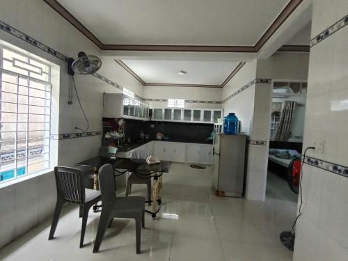 a kitchen with a table and chairs in a room at Hải Yến in Ba Ha