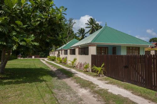a house with a green roof and a fence at Le Relax Self Catering Apartment in La Digue