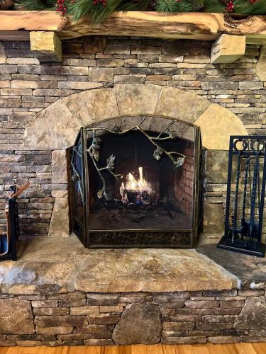 a fireplace in a stone wall at Fall25 Offhottubviewsfirepitwcu3minfamilies in Sylva