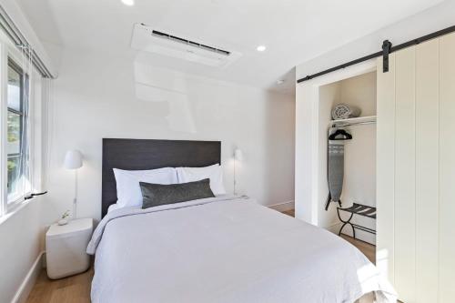 a white bedroom with a large bed and a window at Casa Jardin - Boutique Suites in Downtown Santa Barbara in Santa Barbara