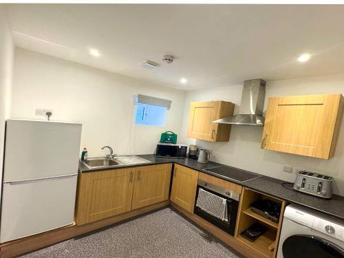 a kitchen with wooden cabinets and a white refrigerator at Taigh Mor in Elgin