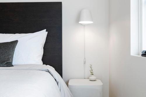 a bedroom with a white bed and a lamp at Casa Jardin - Boutique Suites in Downtown Santa Barbara in Santa Barbara