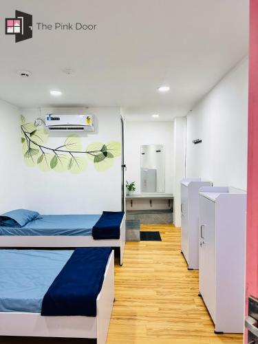 a room with two bunk beds and a bathroom at The Pink Door in Cochin