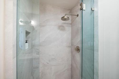 a bathroom with a shower with a glass door at Casa Jardin - Boutique Suites in Downtown Santa Barbara in Santa Barbara