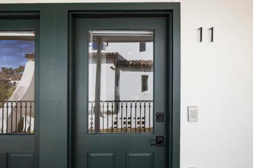 a green door with two windows on a building at Casa Jardin - Boutique Suites in Downtown Santa Barbara in Santa Barbara