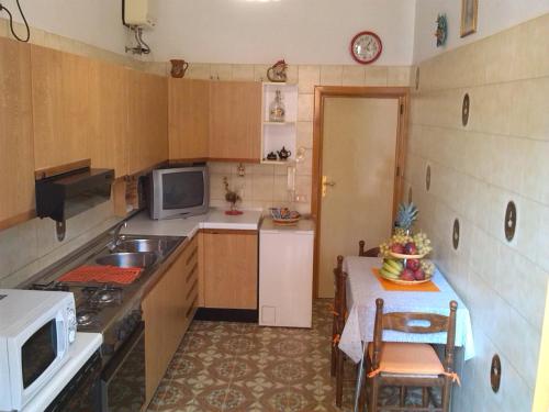 a small kitchen with a table and a microwave at Nice House wifi free bici free in Avola