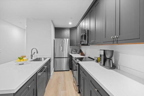 a kitchen with gray cabinets and white counter tops at Casa Jardin - Boutique Suites in Downtown Santa Barbara in Santa Barbara