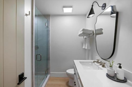 a bathroom with a shower and a sink and a mirror at Casa Jardin - Boutique Suites in Downtown Santa Barbara in Santa Barbara