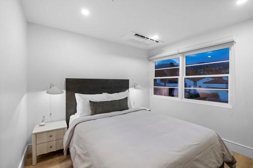 a white bedroom with a bed and a window at Casa Jardin - Boutique Suites in Downtown Santa Barbara in Santa Barbara