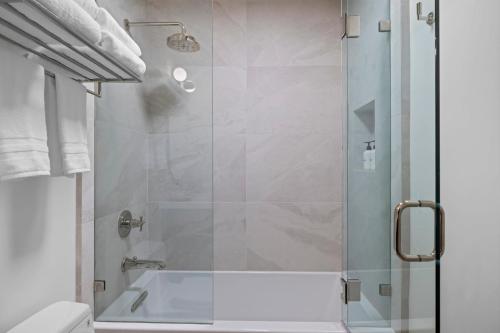 a bathroom with a shower with a glass door at Casa Jardin - Boutique Suites in Downtown Santa Barbara in Santa Barbara