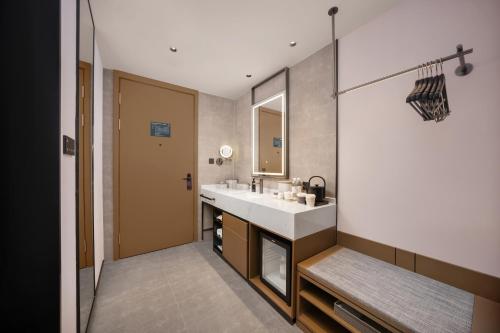 Atour Hotel Wuhan Hankou Riverside Park, Jiefang Avenue في Jiang'an: حمام مع حوض ومرآة