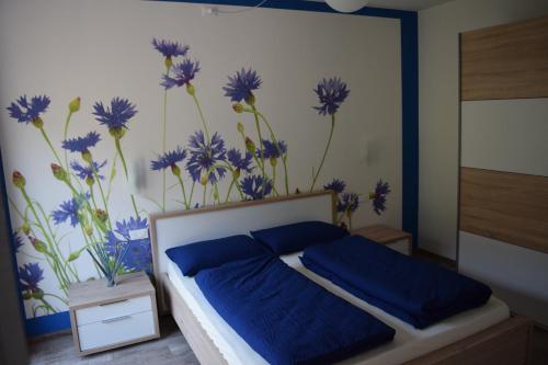 a bedroom with a bed with blue flowers on the wall at "CASABANA" - relax tutto l'anno - giardino - piscina Top in Malcesine