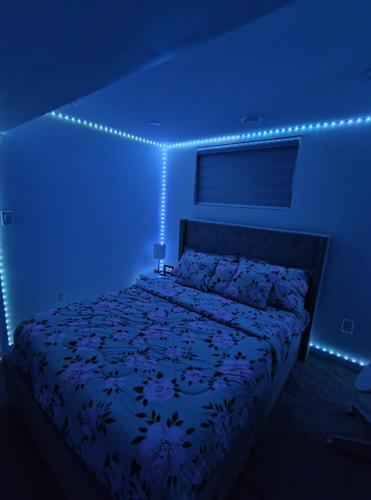 a bedroom with a bed with blue lights on it at ArbyManie's Place Newly Built Apartment in London