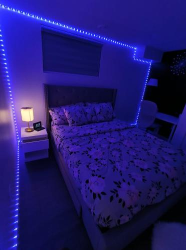 a bedroom with a bed with purple lights at ArbyManie's Place Newly Built Apartment in London