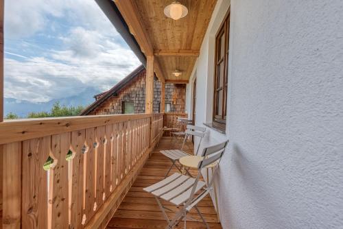 a porch with rocking chairs on a wooden deck at ELA Apartments Traunkirchen in Traunkirchen
