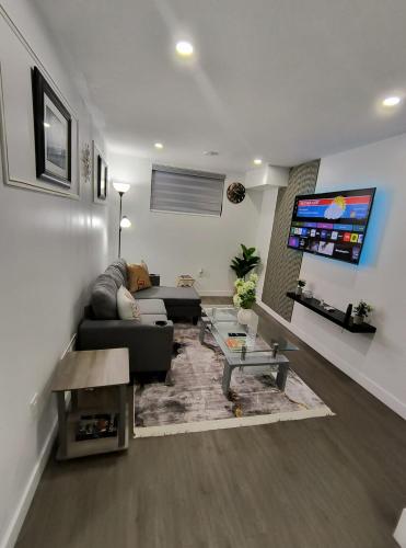 a living room with a couch and a tv at ArbyManie's Place Newly Built Apartment in London
