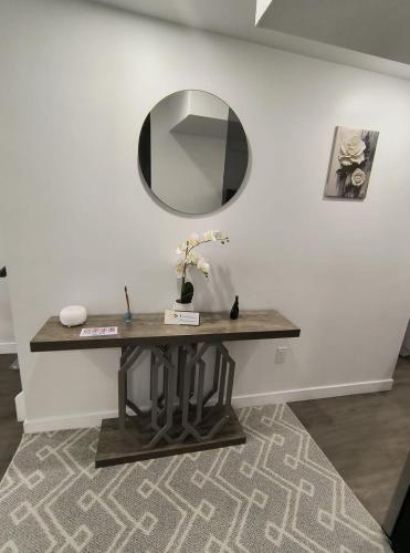 a table with a mirror on a wall at ArbyManie's Place Newly Built Apartment in London
