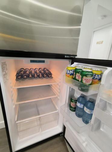 an open refrigerator filled with food and drinks at ArbyManie's Place Newly Built Apartment in London