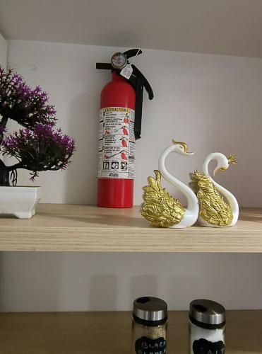 a shelf with a red fire hydrant and swans decorations at ArbyManie's Place Newly Built Apartment in London