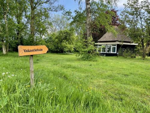 a sign in the middle of a field with a house at Eco Lodge Drenthe in Valthe