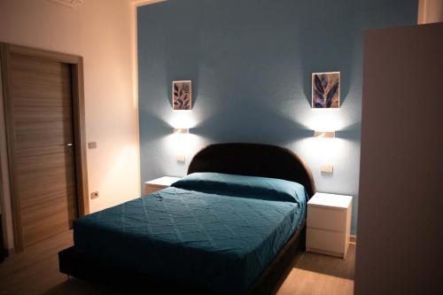 a bedroom with a bed and two lights on the wall at Mhometredici Guest House in Sestu