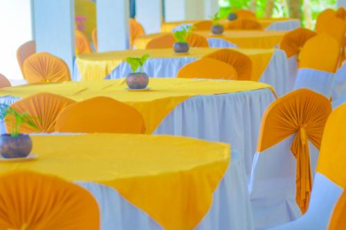 a row of tables with yellow and white at Hotel Water Nest in Etagama