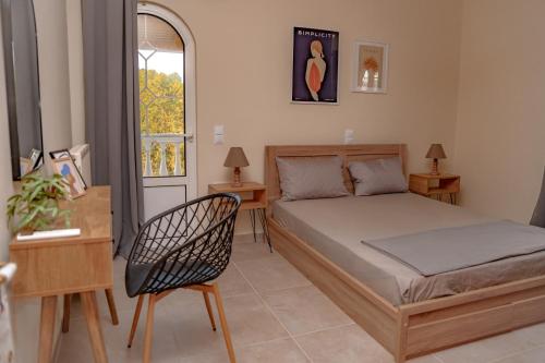 a bedroom with a bed and a chair and a window at Villa Ilianna in Igoumenitsa
