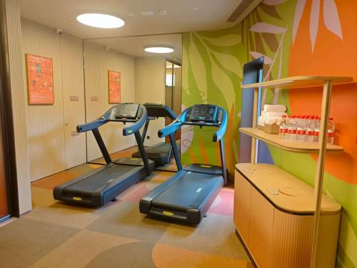 a gym with three exercise bikes in a room at Orange Hotel Beijing Liangxiang University Town in Beijing