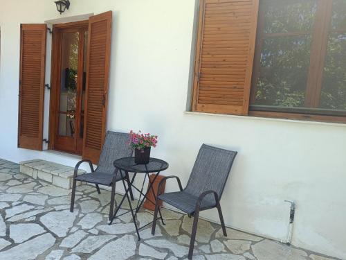 a patio with two chairs and a table with flowers at Delphion House in Arachova
