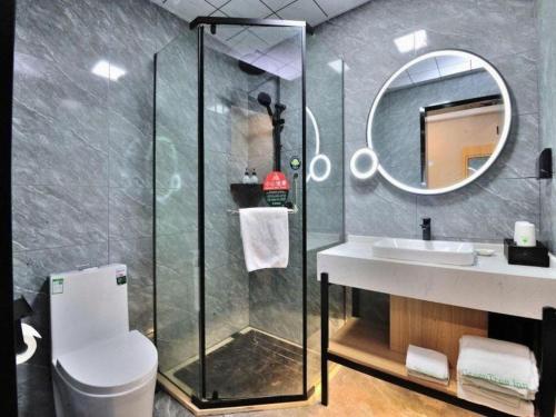 a bathroom with a shower and a sink and a mirror at GreenTree Inn Suzhou Shihu Suli Road Express Hotel in Suzhou
