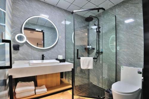 a bathroom with a sink and a shower with a mirror at GreenTree Inn Suzhou Shihu Suli Road Express Hotel in Suzhou
