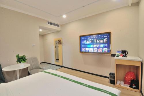 a hospital room with a bed and a tv on the wall at GreenTree Inn Suzhou Shihu Suli Road Express Hotel in Suzhou