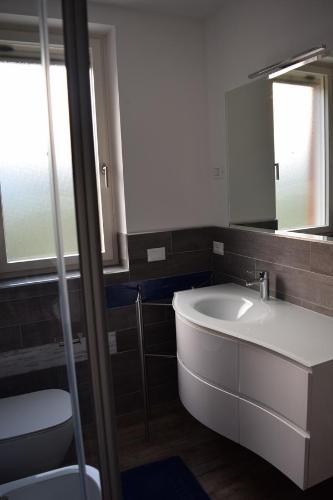 a bathroom with a sink and a mirror at "CASABANA" - relax tutto l'anno - giardino - piscina Top in Malcesine