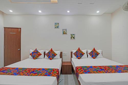 two beds sitting in a room with at FabExpress Kaveri Executive - Nr Alandi vithoba temple in Pune