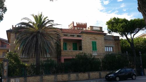 a brick house with a palm tree in front of it at Appartamento Esmeralda in Tortoreto Lido