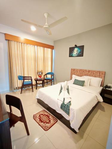 a bedroom with a bed and a table and chairs at Sylhet Paradise Inn in Sylhet