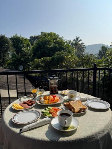 a table with plates of food and a cup of coffee at charlotte inn in Gampola