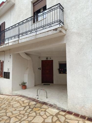 a white building with a door and a balcony at Delphion House in Arachova