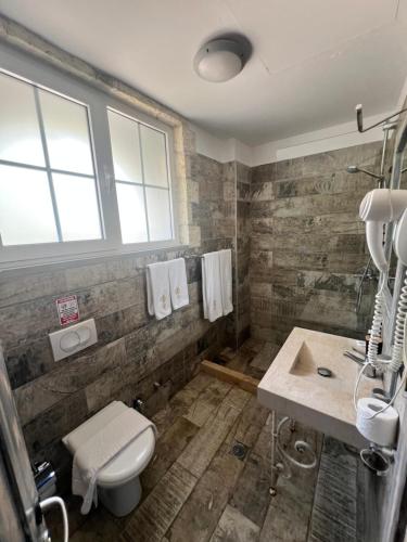 a bathroom with a toilet and a sink at Hotel Sarajet e Pashait 1 in Dhërmi