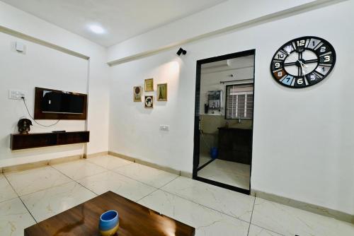 a room with a clock on the wall and a table at One bedroom apartment in Indore