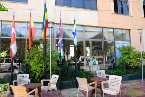 a group of flags and tables and chairs in front of a building at Sabean International Hotel in Āksum