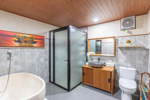 a bathroom with a tub and a toilet and a sink at Ubud Suarga Private Pool Villa in Ubud