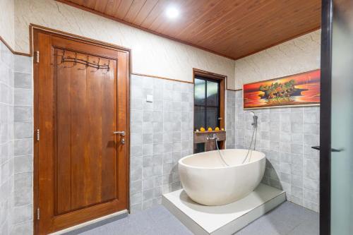 a bathroom with a large tub in the corner at Ubud Suarga Private Pool Villa in Ubud