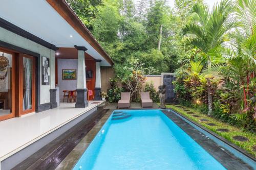 a swimming pool in the backyard of a house at Ubud Suarga Private Pool Villa in Ubud