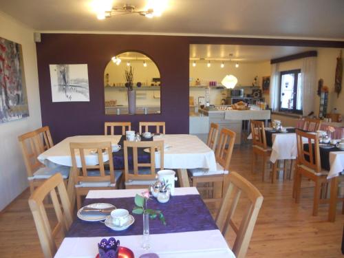 ein Restaurant mit Tischen und Stühlen und eine Küche in der Unterkunft Landhaus Schoenen in Sasbachwalden