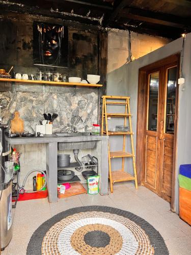 a kitchen with a counter with a sink and a ladder at My Kubu in Jembrana