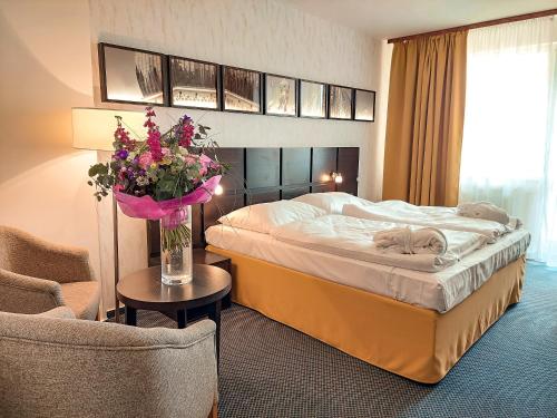 a hotel room with a bed and a chair at Hotel Frymburk in Frymburk