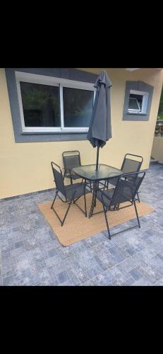 a table with two chairs and an umbrella at Danny's Rural Suite T2 in Curral das Freiras