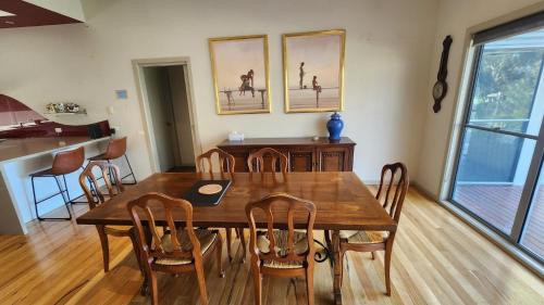 a dining room with a wooden table and chairs at Le Pelican - Metung Family Retreat in Metung