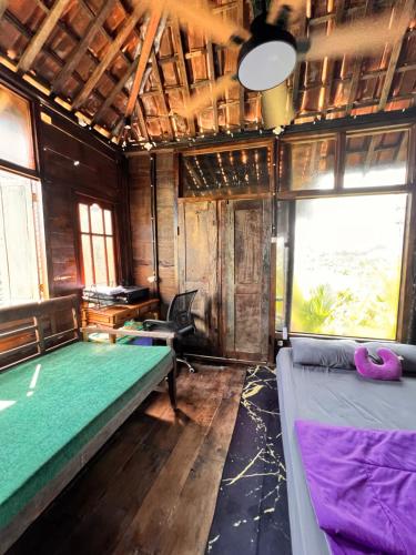 a room with two beds and a window at My Kubu in Jembrana